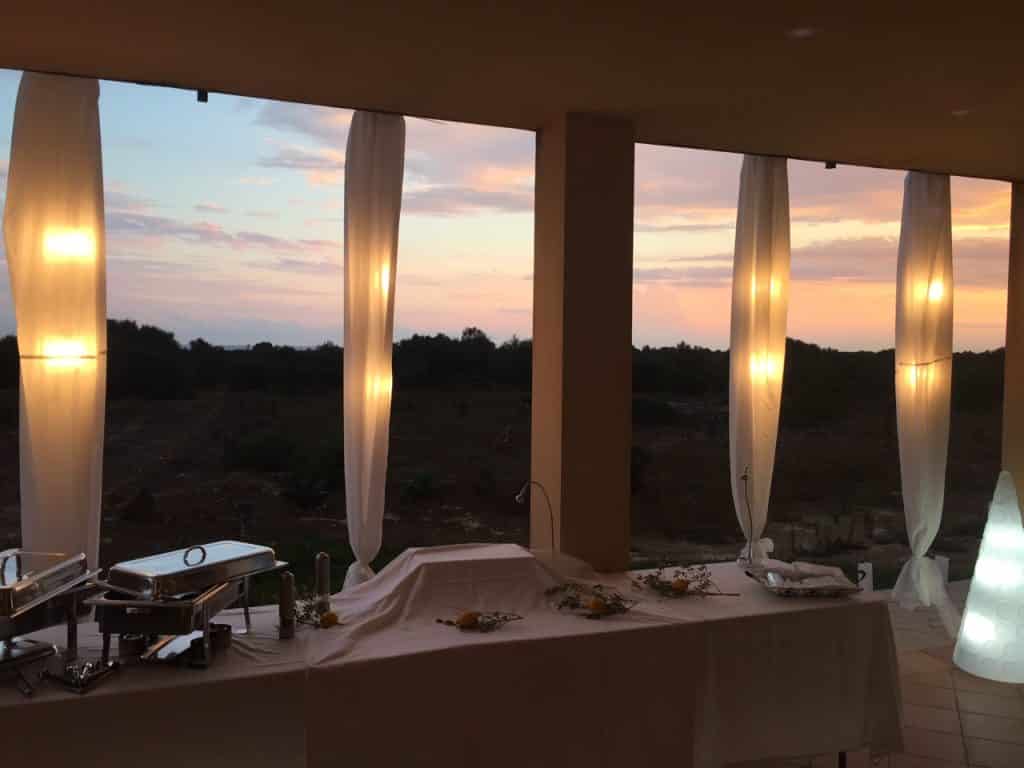 Buffet de catering nocturno con vistas panorámicas a través de grandes ventanales en Mallorca.